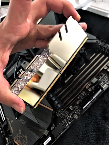 Holding a new RAM module by its edges in order to insert it into a PC