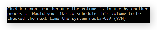 Símbolo del sistema mostrando un mensaje de error que indica que otro proceso está usando el volumen, y pidiéndole al usuario si le gustaría programar ese volumen para que se compruebe la próxima vez que se reinicie el sistema.