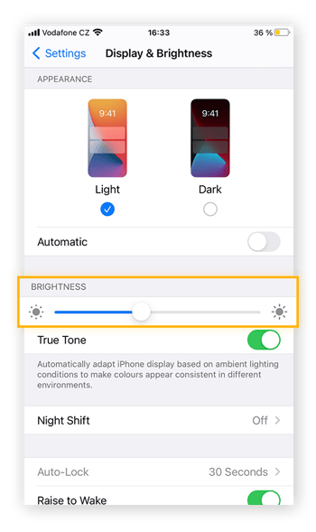 Reduza o brilho da tela no iPhone, acessando o aplicativo Ajustes e ajustando o brilho na guia Tela e Brilho.