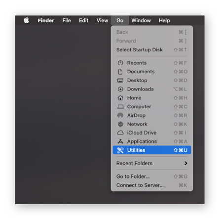 Pantalla de inicio del Mac con «Ir» seleccionado en la barra del menú superior y «Utilidades» seleccionado en el menú desplegable.