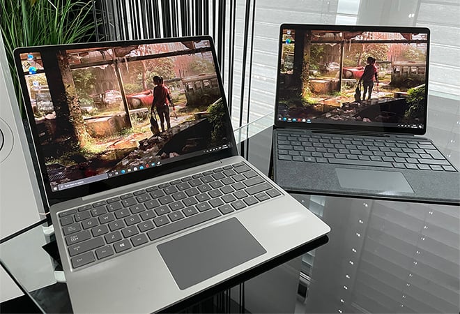 Dois laptops colocados em uma mesa de vidro lisa