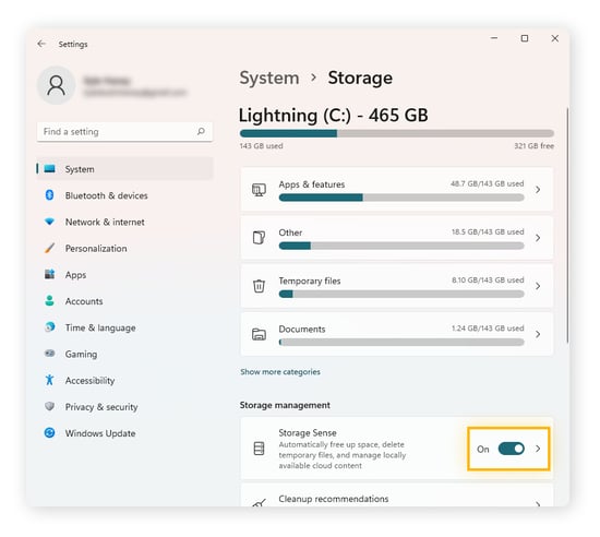 Toggling on Storage Sense, which automatically deletes temp files regularly, on Windows 11.