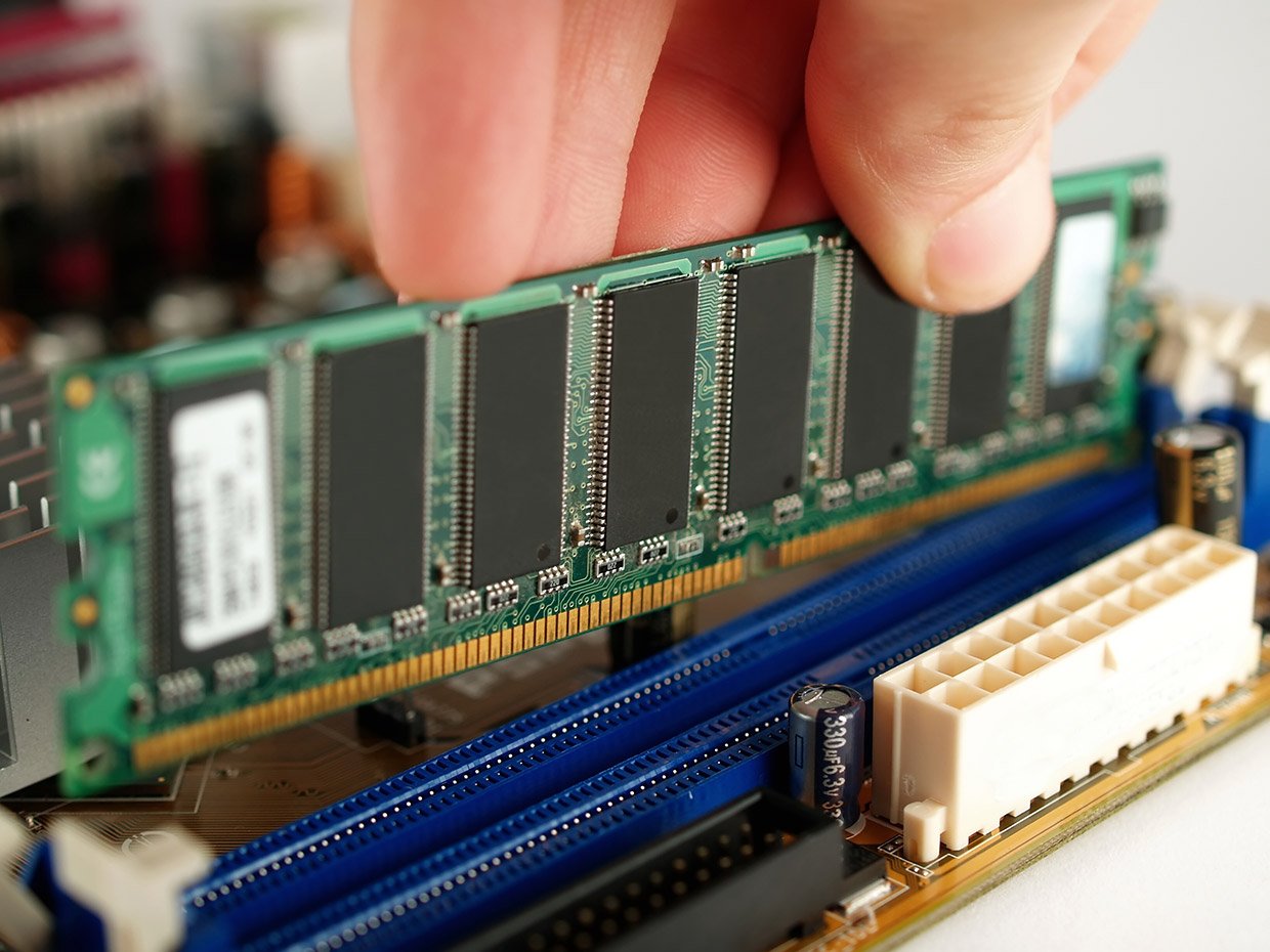 Inserting RAM sticks into a computer's motherboard.